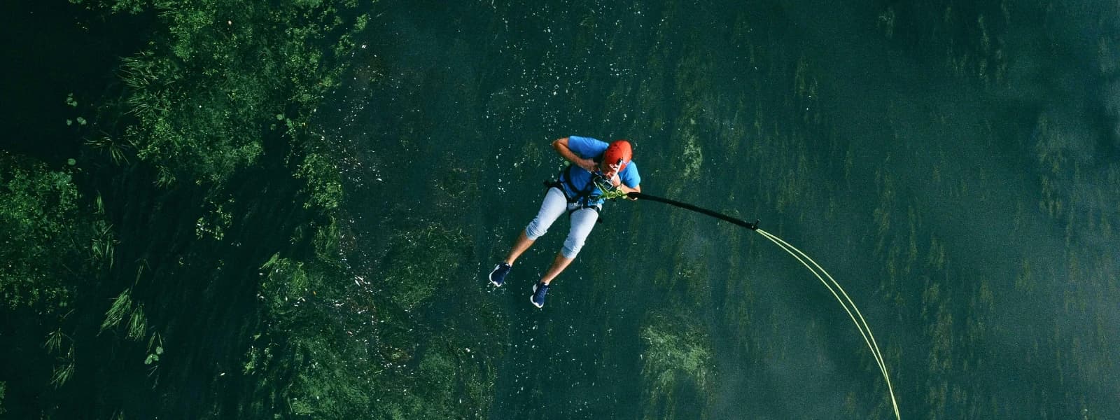 View of the best bungee jumping spot in Pokhara, Nepal, surrounded by mountains and lush greenery.