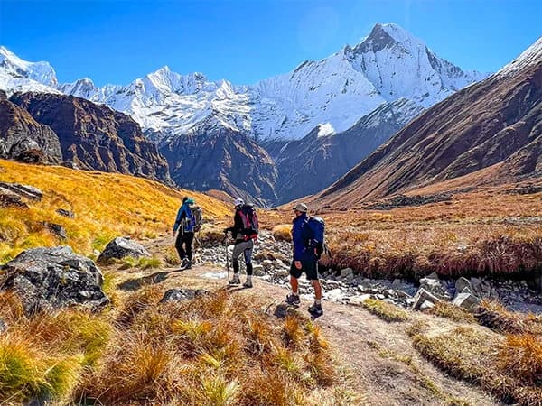 Trekkers on the trail to Annapurna Base Camp, surrounded by towering Himalayan peaks.