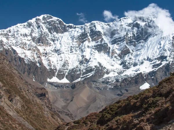 A panoramic view of the Annapurna Base Camp, highlighted by a bright blue sky.