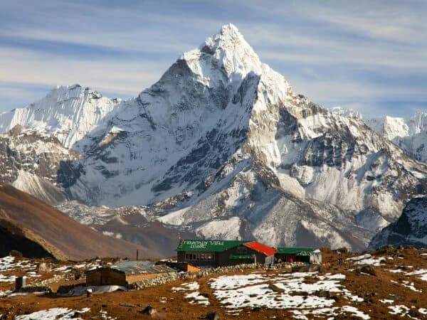 Small plane taking off from the runway at Lukla Airport, with the Himalayas in the background