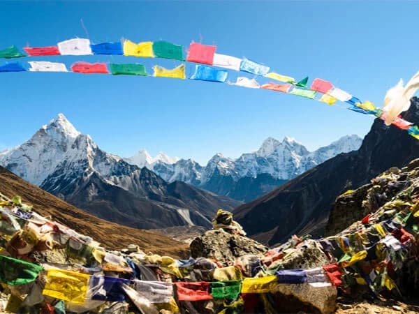 Colorful prayer flags fluttering in the wind against the backdrop of Everest.